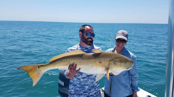 Client holding a Red Drum caught on a Pamlico Sound charter.